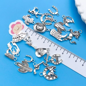 Macro view of vintage silver cowboy charms with a ruler showing size on blue background