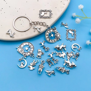 Antique silver Easter bunny and clock charms set for DIY jewelry making on blue background