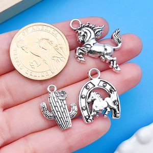 Macro view of antique silver western charms next to a coin for size reference
