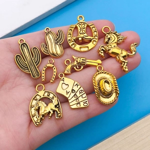 Détails de breloques de cowboy dorées antiques pour bijoux DIY présentées dans la main