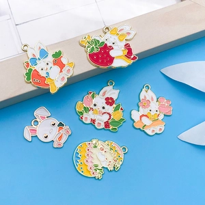 Close-up of enamel bunny pendants with strawberry, carrot, and flower charms for DIY