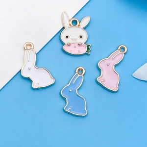 Detail of four colorful enamel bunny charms with carrot accents for DIY jewelry making