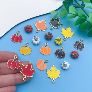 Detail of colorful enamel pumpkin and maple leaf pendants for DIY jewelry crafting