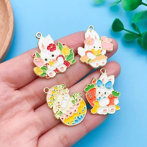 Nahaufnahme von vier bunten Emaille-Osterhasen-Anhängern mit Goldrand für DIY-Schmuck
