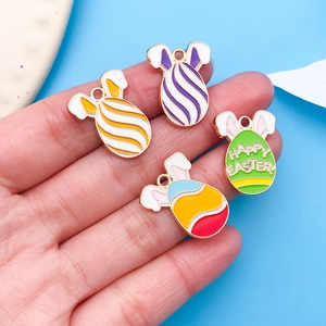 Macro detail of Easter bunny and colorful egg charms held by hand for jewelry DIY