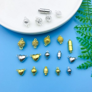 Assorted gold and silver magnetic jewelry clasps in heart, sphere, and cylinder shapes