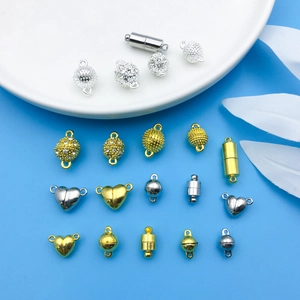 Close-up of magnetic jewelry clasps in heart, sphere, and cylinder shapes for DIY crafts