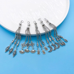 Detailed macro view of five vintage silver alloy tassel charms for DIY jewelry making