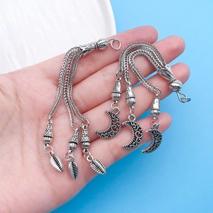 Detail of vintage silver fringe pendants with hollow moon and leaf charms for jewelry making