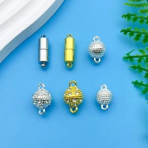Detailed view of silver and gold magnetic jewelry clasps with rhinestones on blue background
