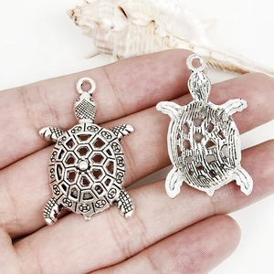 Detailed view of vintage silver turtle charms for DIY jewelry making necklaces and bracelets