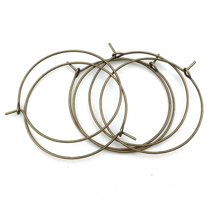 Detalle de cuatro aros metálicos de bronce para pendientes DIY con cierre de gancho
