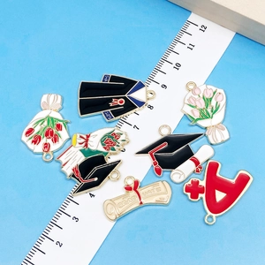 Detailed close-up of colorful graduation charms including cap and flowers for DIY jewelry