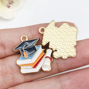 Macro view showing the front enamel design and textured back of graduation cap pendant