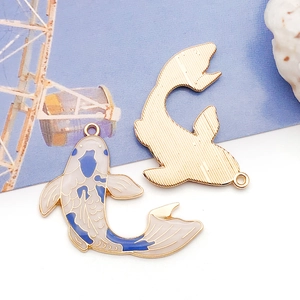 Detail of blue koi carp enamel charms showing front enamel and gold textured back sides