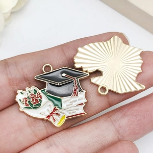 Detailed front and back view of a graduation cap and floral enamel metal charm pendant
