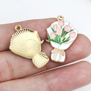 Macro shot of tulip bouquet charms with pink enamel petals and golden textured back
