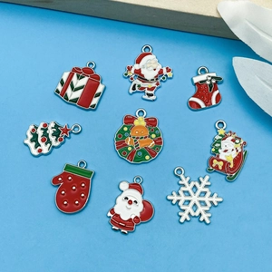 Detalle macro de colgantes navideños con Papá Noel y muñecos de nieve para joyería artesanal