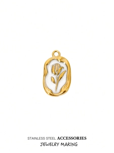 Detail view of oval stainless steel charm with a golden tulip and white enamel base