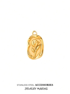 Macro view of gold stainless steel oval pendant with embossed tulip floral pattern