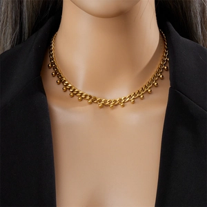 Collier chaîne cubaine dorée minimaliste avec perles porté par un mannequin chic