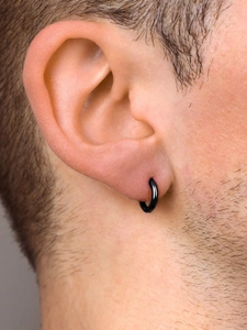 Gros plan d'une boucle d'oreille créole minimaliste en acier noir portée au cartilage