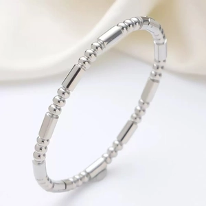 Bracelet jonc perlé en argent poli avec segments cylindriques sur fond de soie blanche