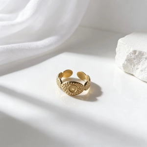 Anillo vintage ajustable de acero inoxidable dorado con relieve ovalado sobre seda blanca