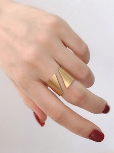 Gros plan sur une bague ajustable géométrique or mat avec un design minimaliste triangle