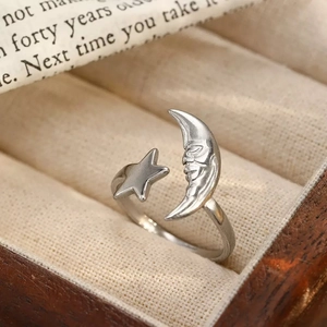 Primer plano detallado de un anillo abierto vintage de luna y estrella en lino beige