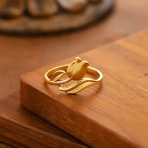 Elegante anillo de tulipán dorado con detalles de hojas sobre una base de madera