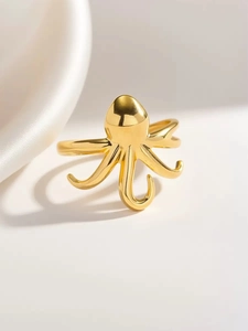 Vista macro de anillo con forma de pulpo dorado y acabado de espejo sobre fondo blanco