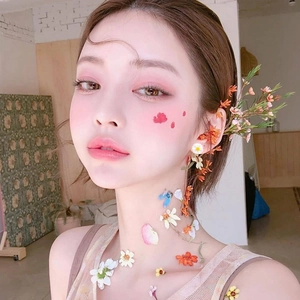 Close-up of elegant floral makeup design with soft pink tones and 3D flower accents