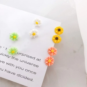 Set of four pairs of colorful S925 daisy stud earrings in white, green, yellow, and pink