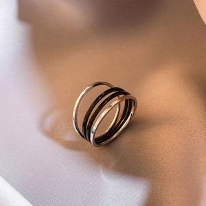 Bague multicouche minimaliste en acier titane avec anneaux argentés et noirs sur tissu