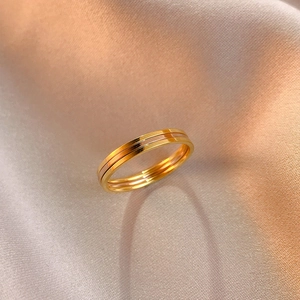 Détail d'une bague minimaliste tricolore en or et argent sur un tissu de soie doux