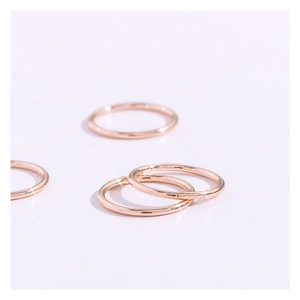 Detalle macro de anillos finos minimalistas de acero de titanio oro rosa con acabado pulido