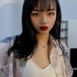 Gros plan d'un collier minimaliste en or avec petits carrés porté par un mannequin femme