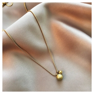Detail van de gouden slangenketting met matte en gepolijste ronde kralenhangers