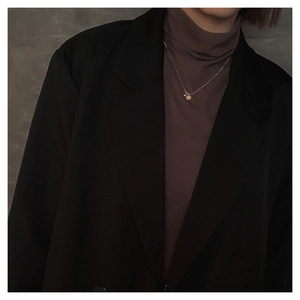 Detailopname van een matgouden bolhanger aan een fijne slangenketting choker voor dames
