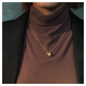 Detailopname van de vergulde choker met een matte kraal en een gepolijste glanzende kraal