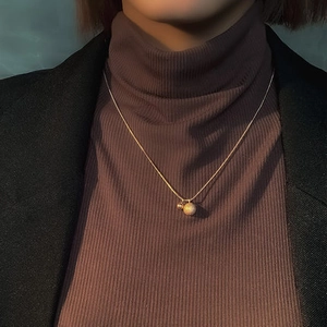 Elegante gouden choker met matte kraal en gepolijste kraal aan een fijne slangenketting