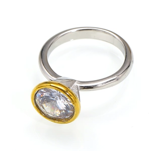 Detail of a two-tone ring featuring a large round zircon and polished 18k gold plated finish
