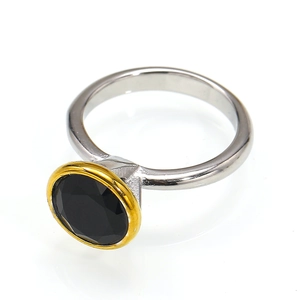 Detail of a round black gemstone ring with silver band and gold bezel setting