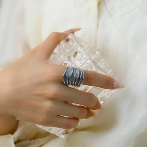 Macro shot of silver-tone titanium ring with vintage rippled texture on wide band
