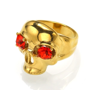 Detail of vintage gold skull ring with red crystal eyes in gothic biker style