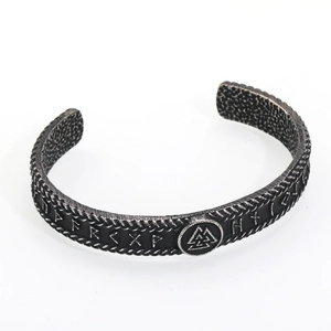 Dettaglio macro del bracciale vichingo con simbolo Valknut e incisioni di rune norrene