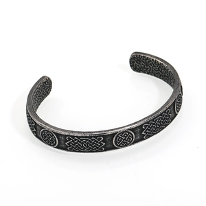 Dettaglio ravvicinato dei nodi celtici e della texture martellata su un bracciale in acciaio