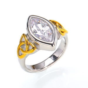 Detailed macro view of marquise-cut crystal and gold triquetra knots on two-tone steel ring