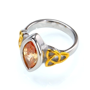 Macro detail of marquise cut orange stone and golden celtic knot on steel ring